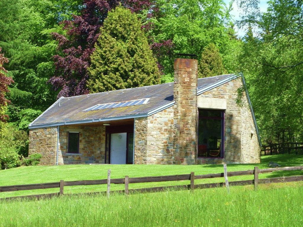 斯图蒙Attractive holiday home in Stoumont with garden的田野上带围栏的小砖屋