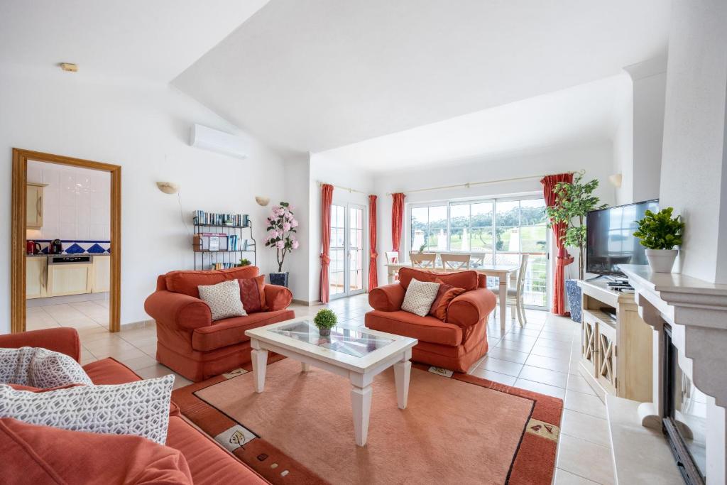 布德恩斯Casa Ensolarada的客厅配有红色椅子和桌子