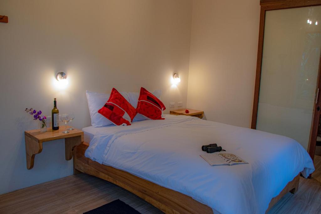 明多卡巴尼亚斯山林旅馆的卧室配有带红色枕头的大型白色床