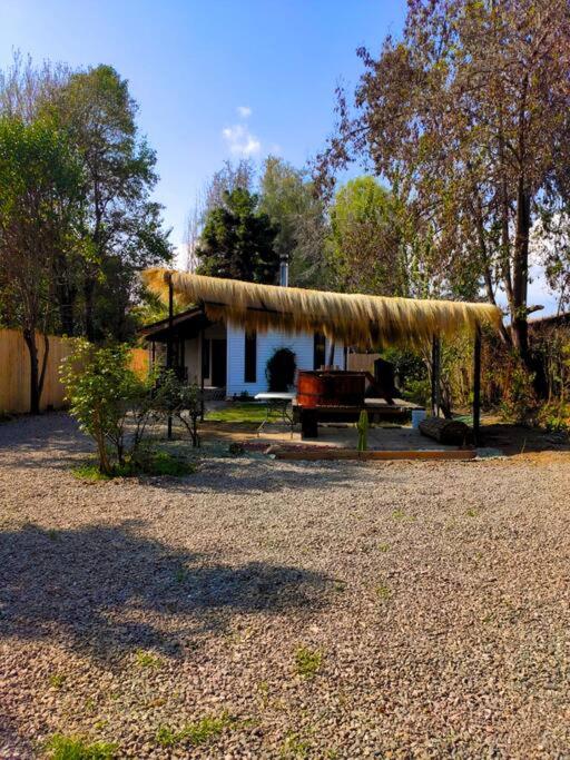 皮尔克Moderna Cabaña con tinaja caliente的茅草屋顶房屋,前面设有长凳