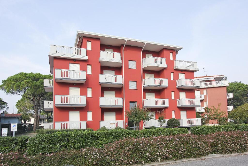 利尼亚诺萨比亚多罗Residenza Cedri的红色的公寓楼,设有白色阳台