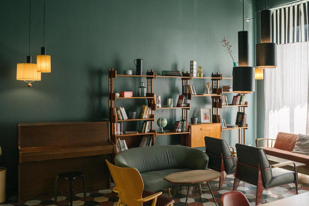 米兰卡萨贝斯青旅的客厅设有绿色的墙壁和桌椅