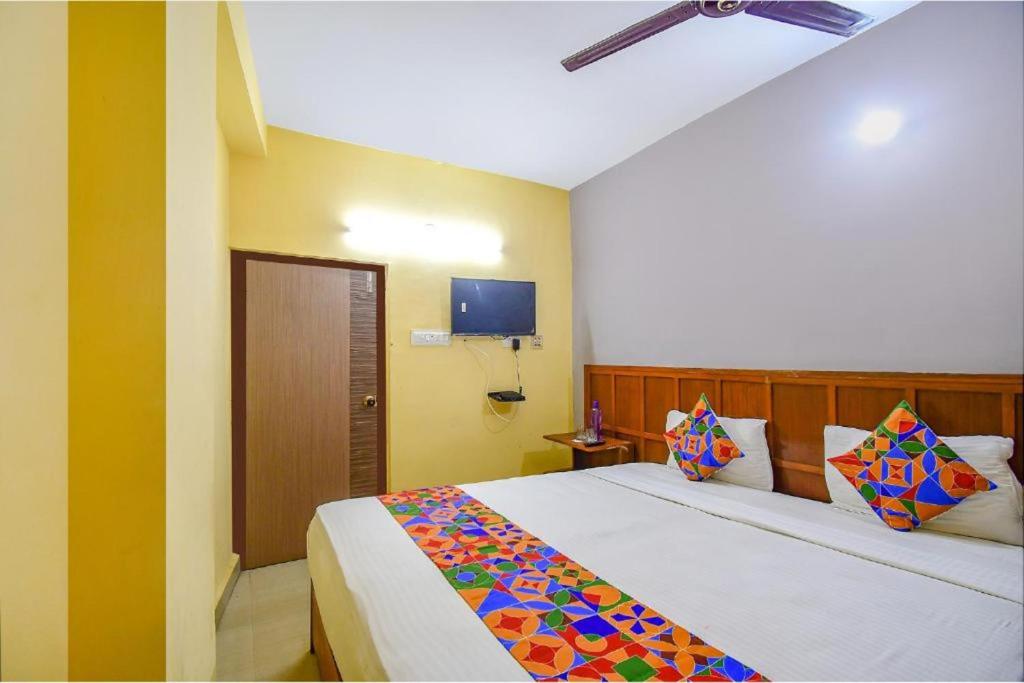 普里Goroomgo Ray Home Stay Swargadwar Puri的卧室配有一张床,墙上配有电视。