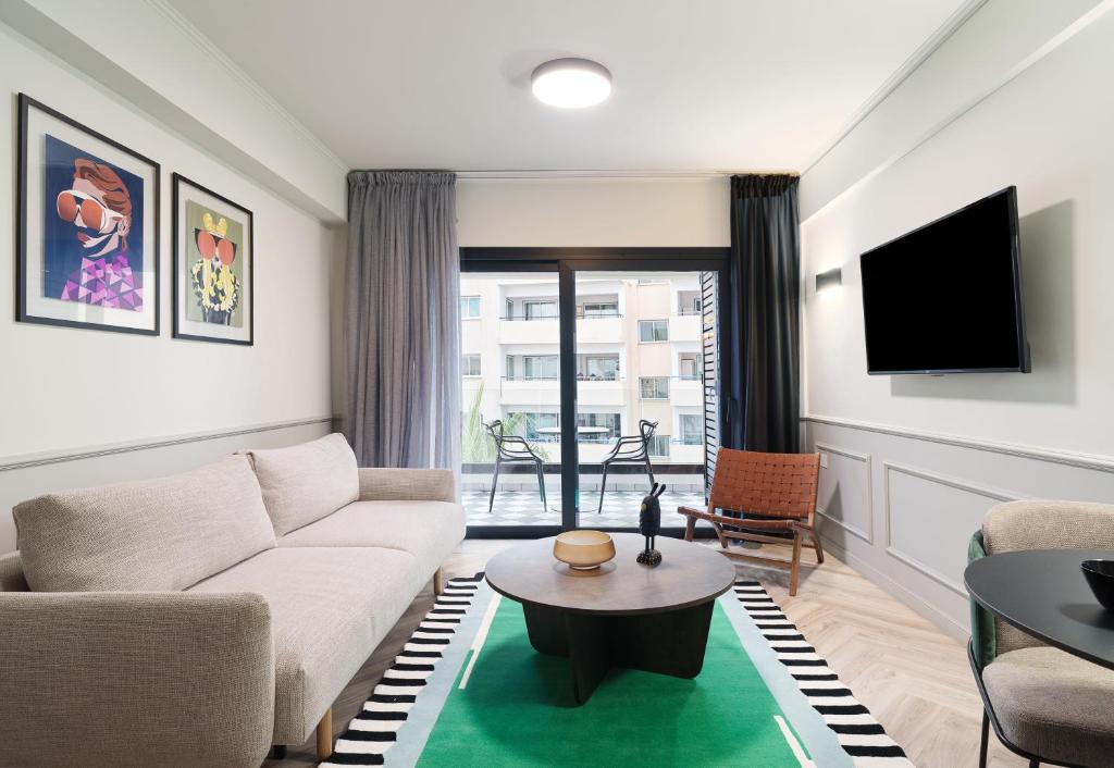 拉纳卡LIV The City Suites ADULTS ONLY的客厅配有沙发和桌子