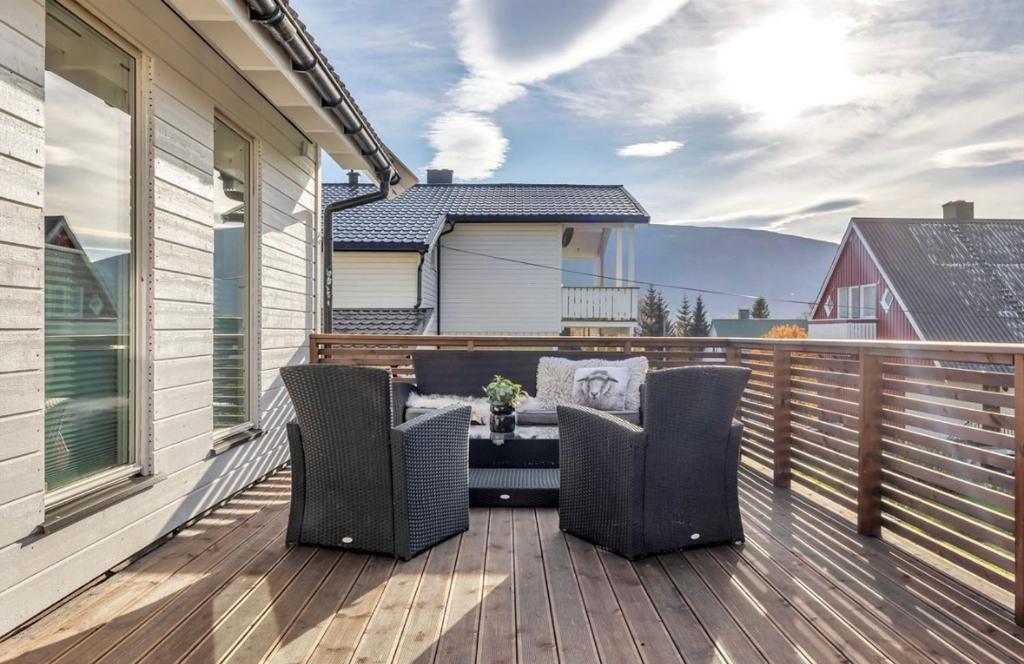 特罗姆瑟Polar Arctic Luxury House - Free parking的房屋内带椅子和桌子的甲板