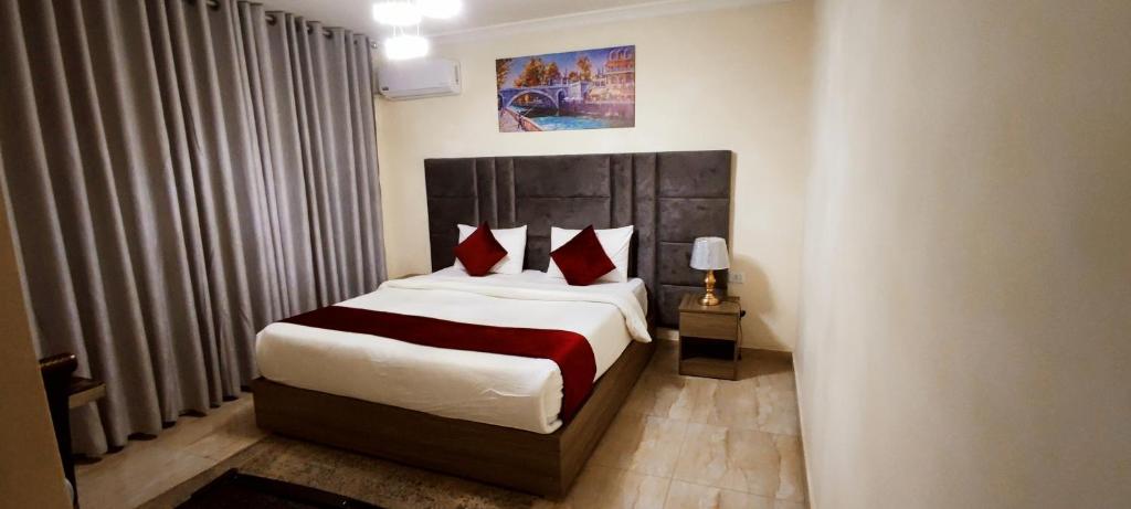 安曼Golden Hotel的一间卧室配有一张带红色枕头的大床