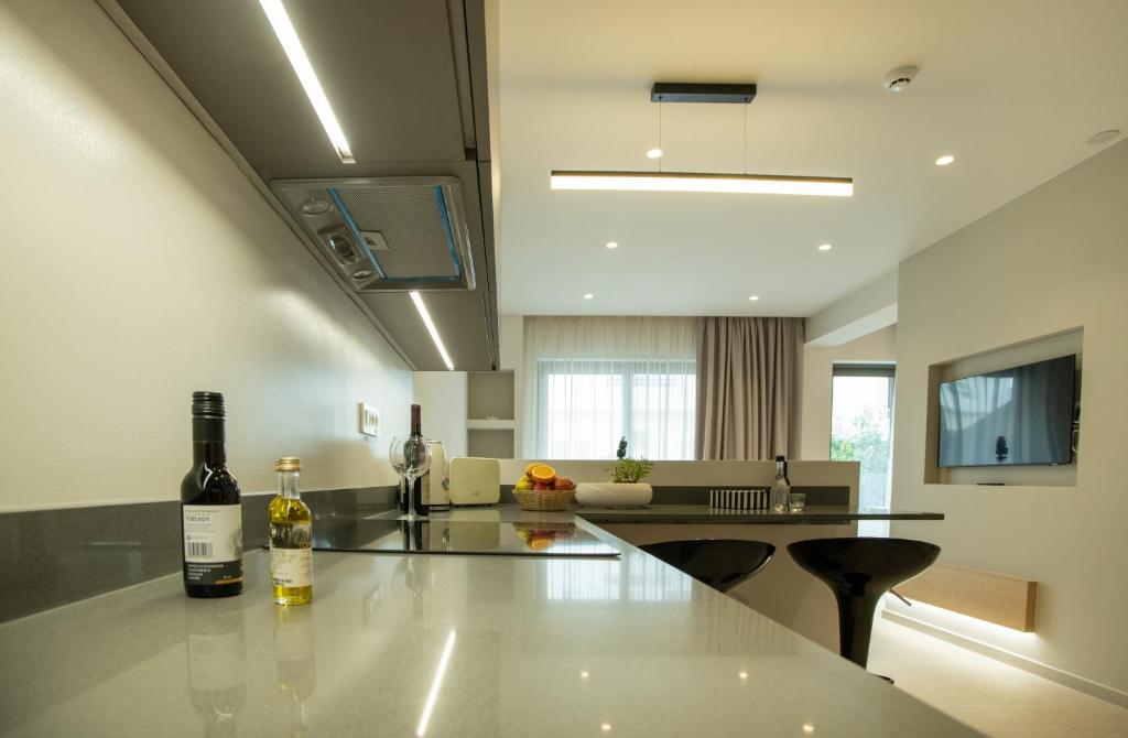 阿基欧斯尼古拉斯Celine Luxury Apartments & Suites的厨房配有带2瓶葡萄酒的桌子
