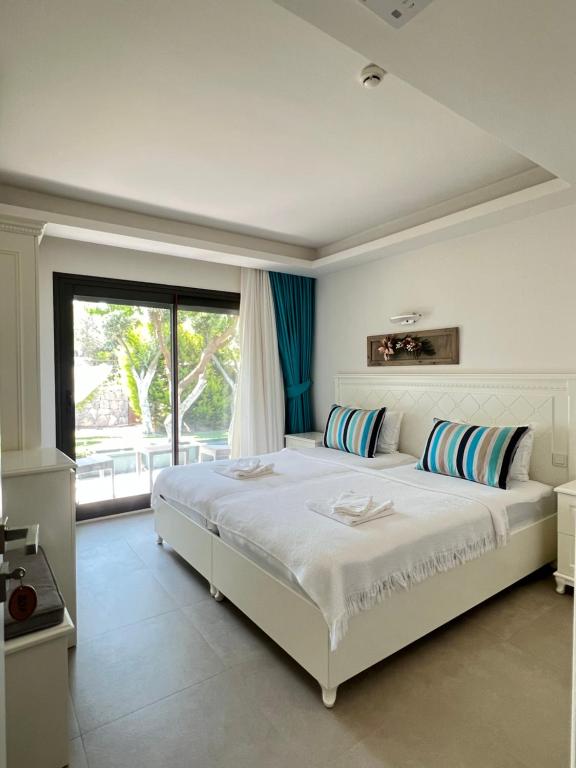 切什梅Dalyan Risus Suite的卧室设有一张白色大床和一扇窗户。