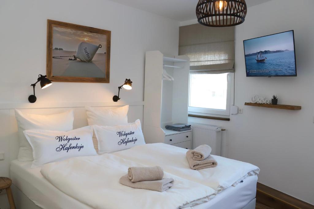 沃尔加斯特Hafenkoje Zum Anker的卧室配有白色床和毛巾