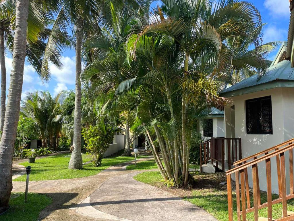 维拉港TRADEWINDS VILLAS的一条棕榈树房子,旁边是人行道