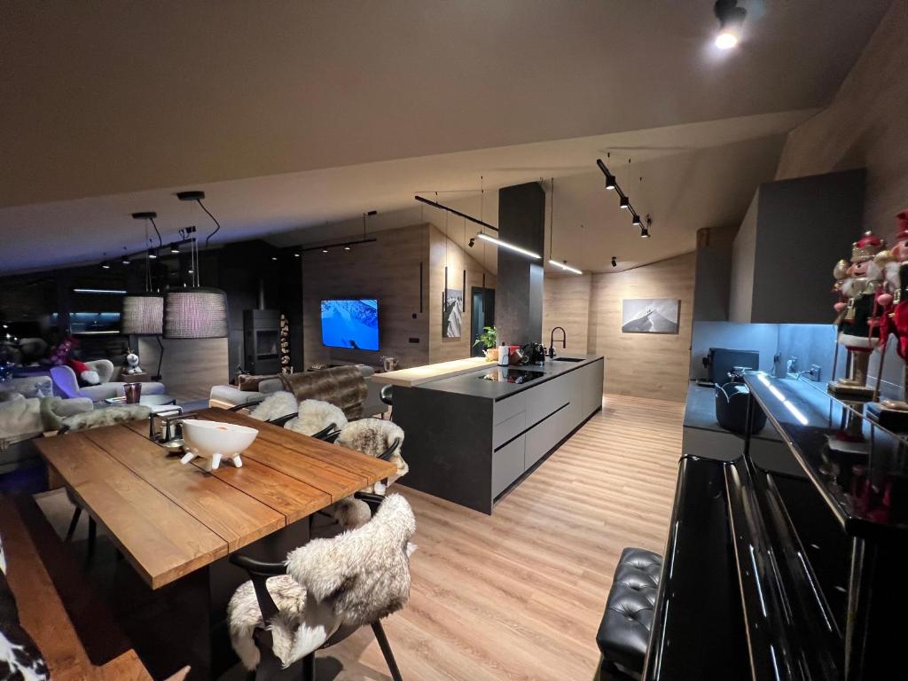 索尔德乌Luxury Summit Penthouse - Soldeu - By Ski Chalet Andorra的客厅配有木桌和羊椅