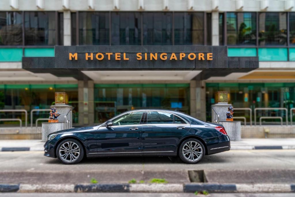 新加坡M Hotel Singapore City Centre的一辆停在一家新加坡酒店前面的蓝色汽车