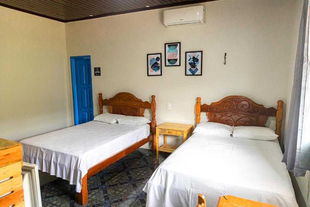 布拉干萨Pousada Aruans Casarão的一间卧室设有两张床和一扇蓝色的门