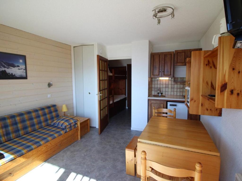 奥瑞斯Appartement Auris, 1 pièce, 3 personnes - FR-1-297-35的客厅以及带沙发和桌子的厨房。