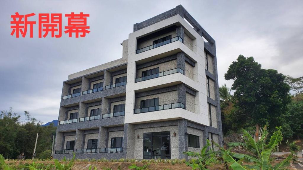 成功镇三仙台日出民宿的一座高大的建筑,在建筑的一侧写字