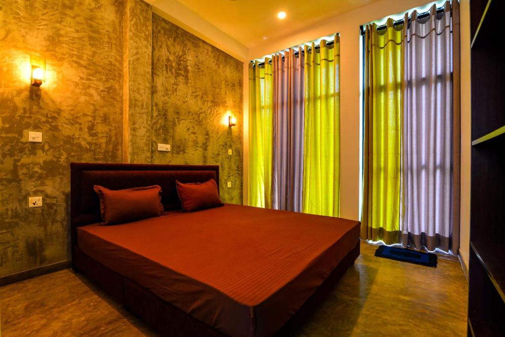 韦利格默2b1 weligama的一间卧室配有一张带绿色窗帘的床