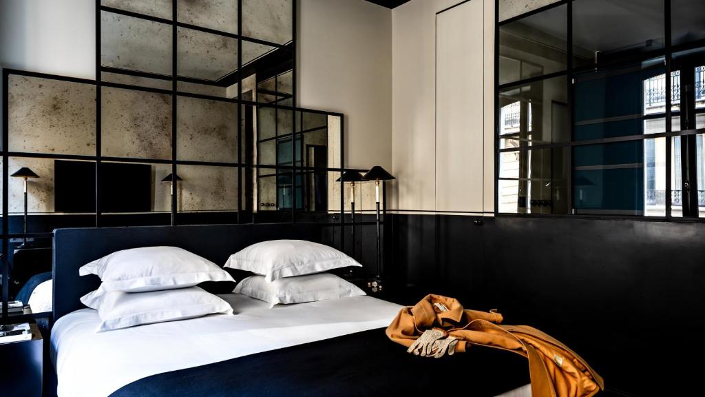 巴黎Monsieur George Hotel & Spa - Champs-Elysées的卧室配有带白色枕头的大床
