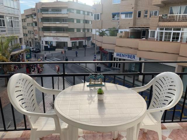 内尔哈Casablanca 1的阳台上配有一张白色的桌子和两把白色的椅子