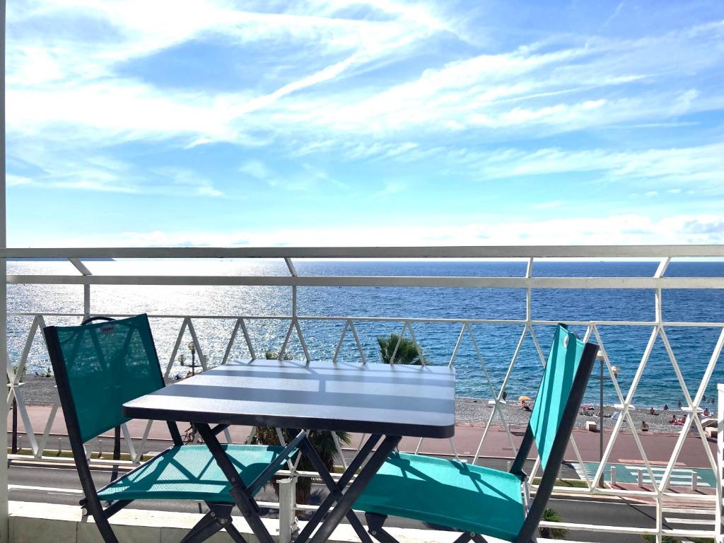 尼斯Residence le Florence的俯瞰大海的阳台配有桌椅