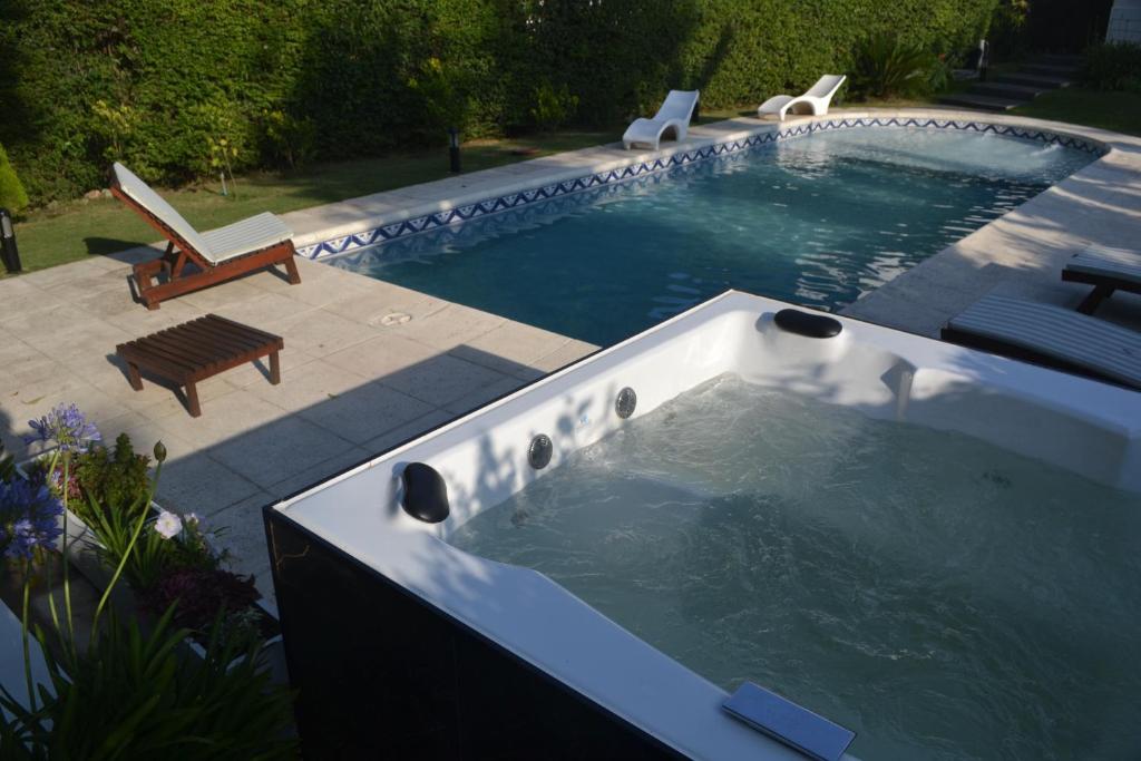 贝尔格拉诺将军镇Casa Simona Villa General Belgrano的一个带热水浴缸和长凳的游泳池