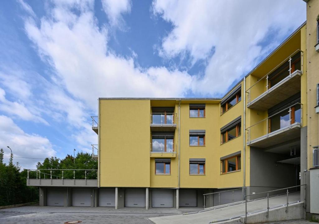 布尔诺EFI Residence Holzova 28的黄色建筑,背景天空