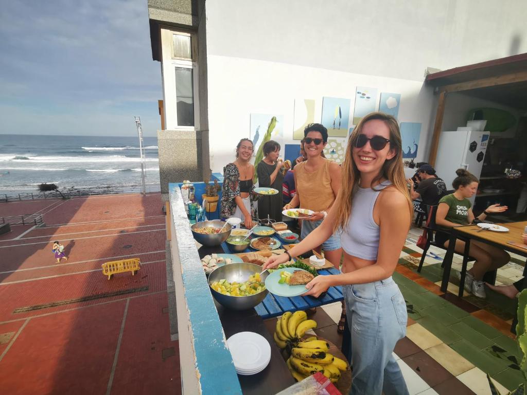 大加那利岛拉斯帕尔马斯La Ventana Azul Surf Hostel的站在食物自助餐前的妇女
