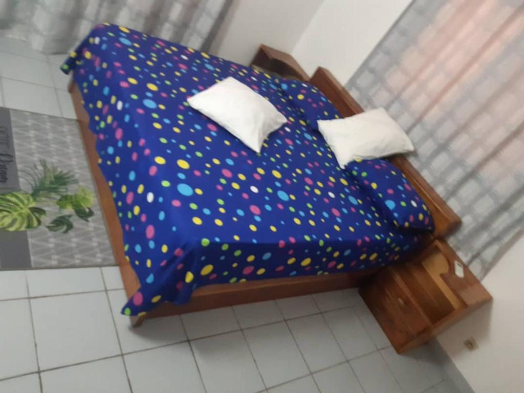 洛美Guesthouse Rotimex的一张床上的模型,上面有波卡点