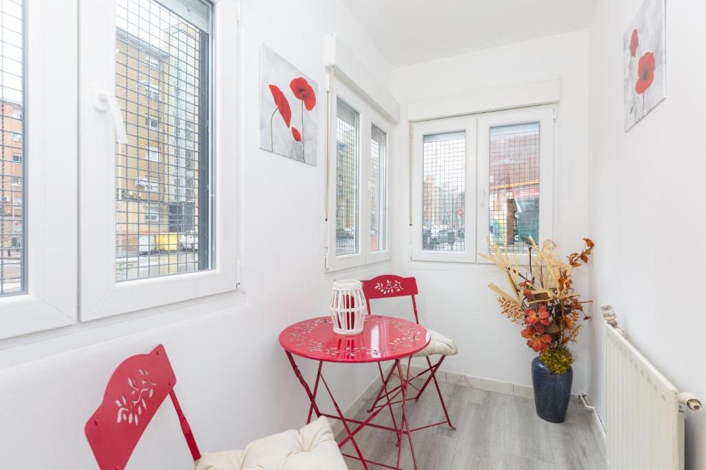 马德里Apartamento Casa de Campo的窗户房间里一张小红桌子