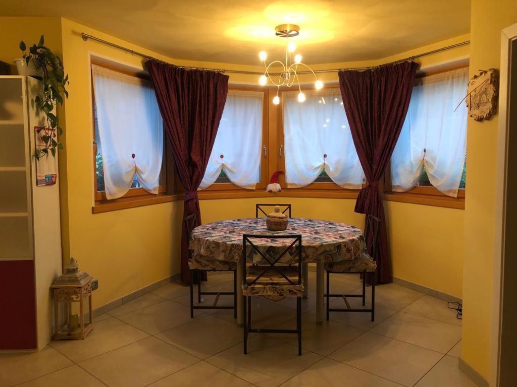 卡里索洛casa Olivieri的一间带桌子和一些窗户的用餐室