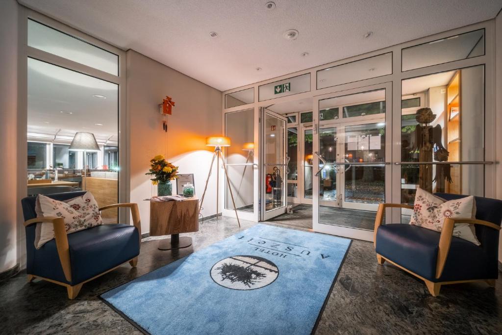 汉堡Auszeit Hotel Hamburg的客厅配有两把椅子和蓝色地毯。