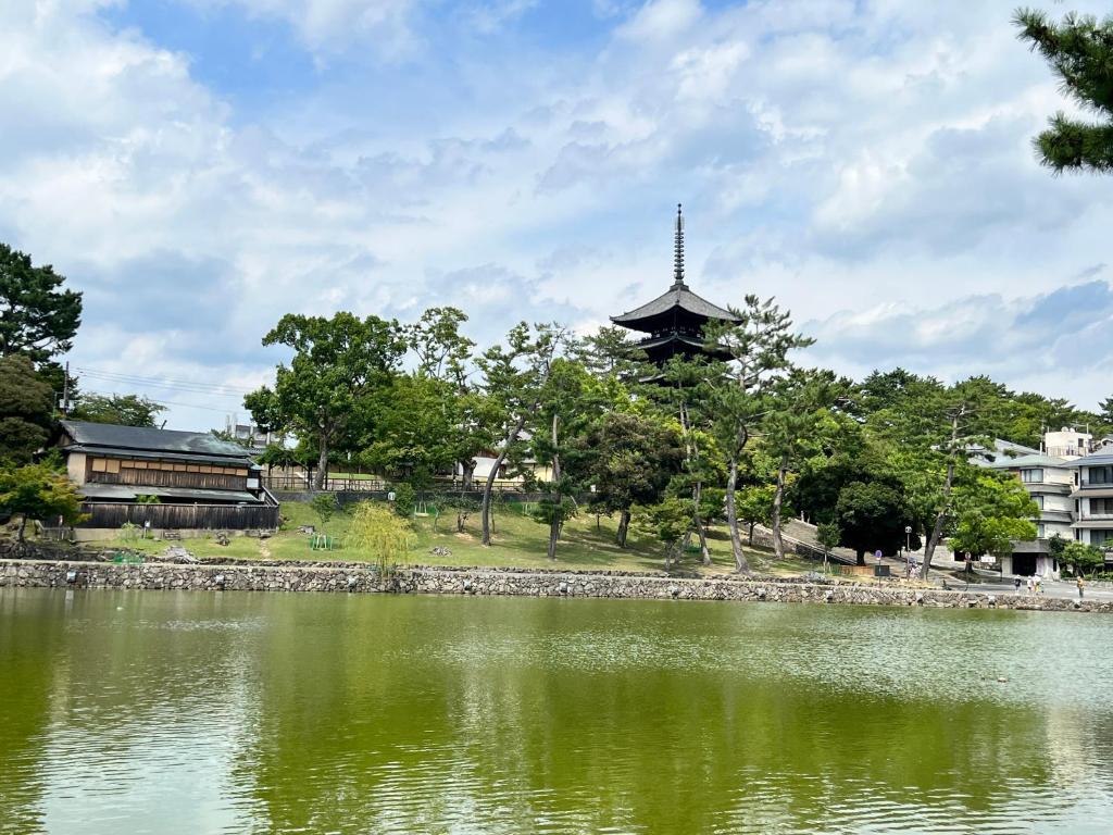 奈良Old modern house in Nara Second的一座建有建筑物的湖前宝塔