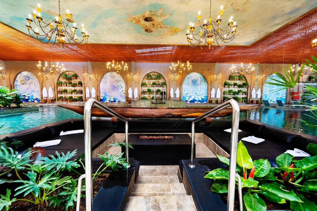 伊克斯雷玛Hotel Villa Lobos Spa Romantik的度假村大堂设有游泳池和植物