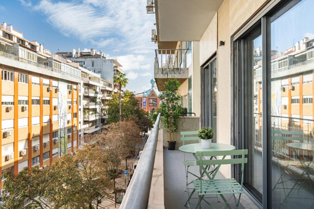 里斯本Succeed Campo Pequeno Apartments的阳台配有桌椅和建筑