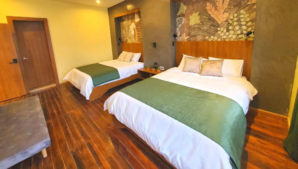 基多Hotel Inti Quito的酒店客房设有两张床,墙上挂有绘画作品
