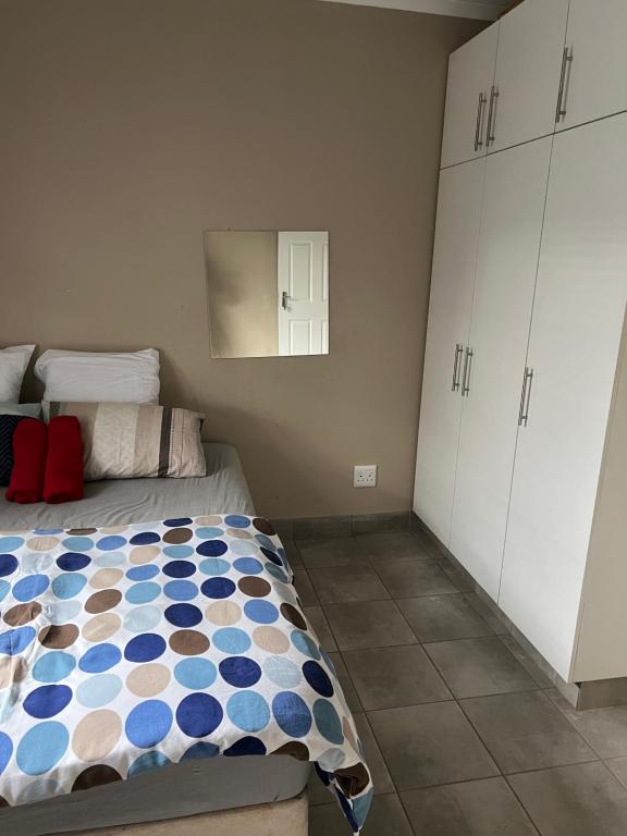 彼得马里茨堡Ikhaya guesthouse2的一间卧室配有床和白色橱柜