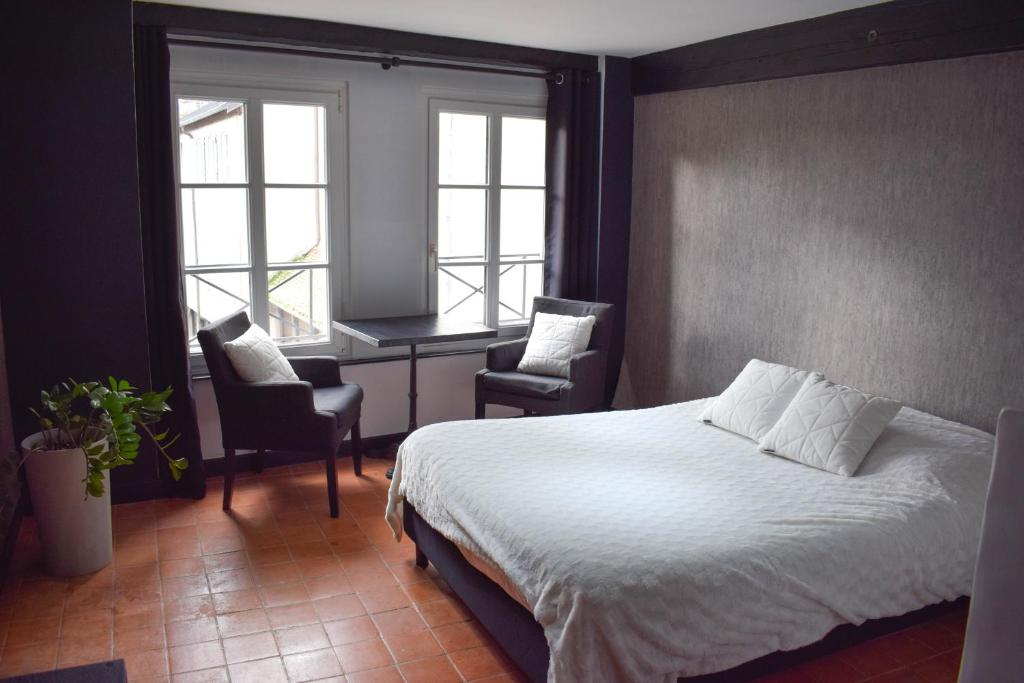 多勒Studio au Moulin " Design Noir " Vue Unique的卧室配有一张床、一张书桌和窗户。