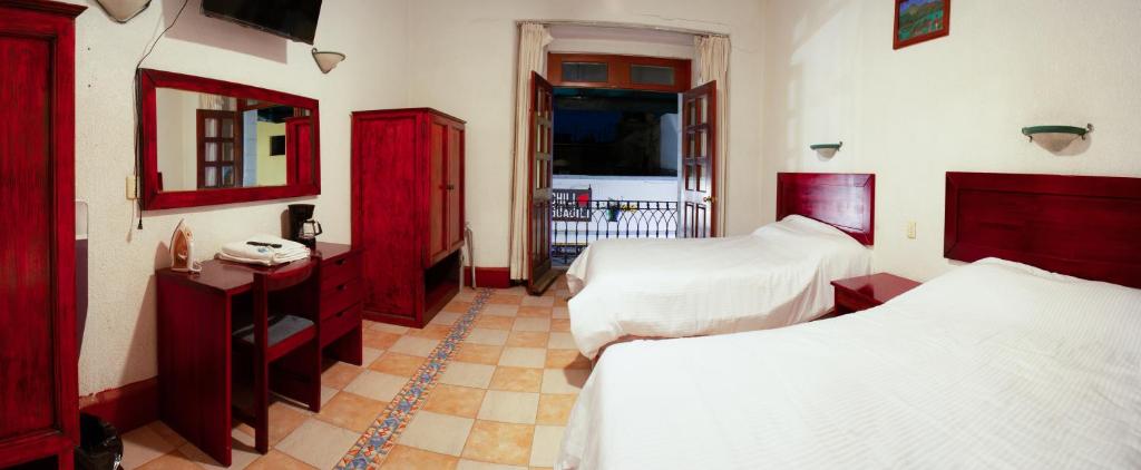 瓦哈卡市Hotel Nueva Antequera的一间卧室设有两张床和红色橱柜。