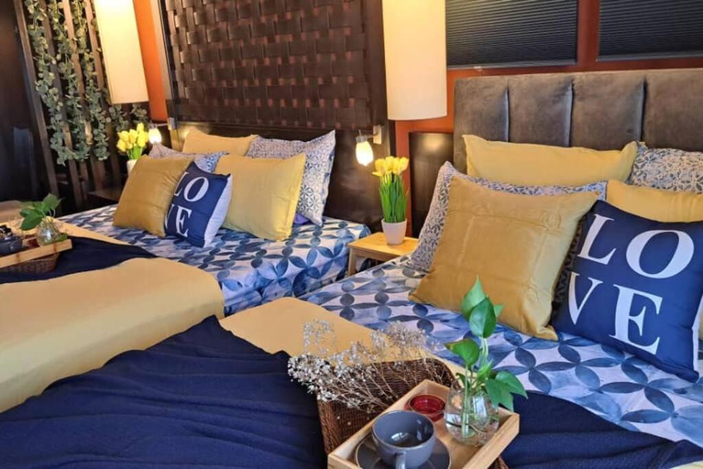 八打灵再也6pax Homestay Resort Suite 1min to Sunway Pyramid的一间卧室配有两张带蓝色和黄色枕头的床