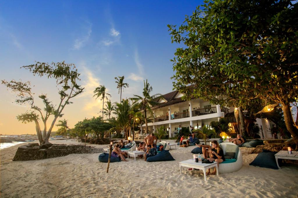 DaanbantayanOcean Vida Beach and Dive Resort的一群人坐在沙滩上