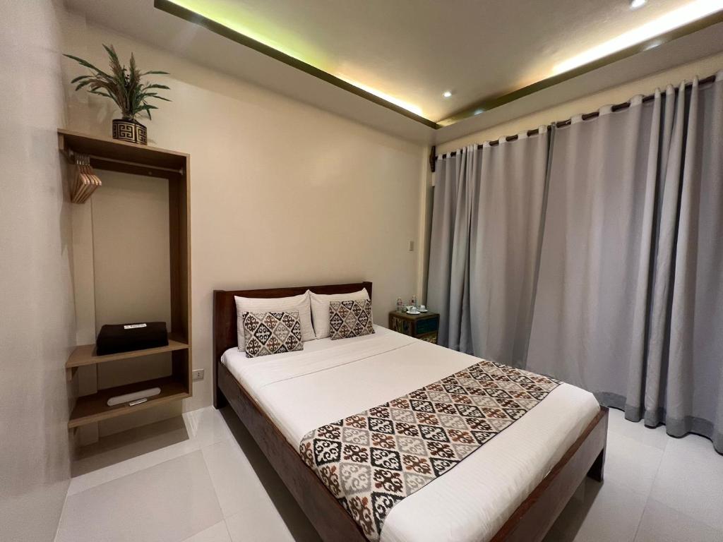 爱妮岛Bulul Garden Resort的一间卧室设有一张床和一个大窗户
