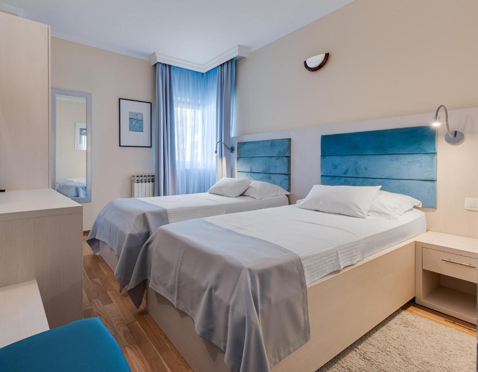扎达尔马林可酒店的一间卧室设有两张床和蓝色床头板