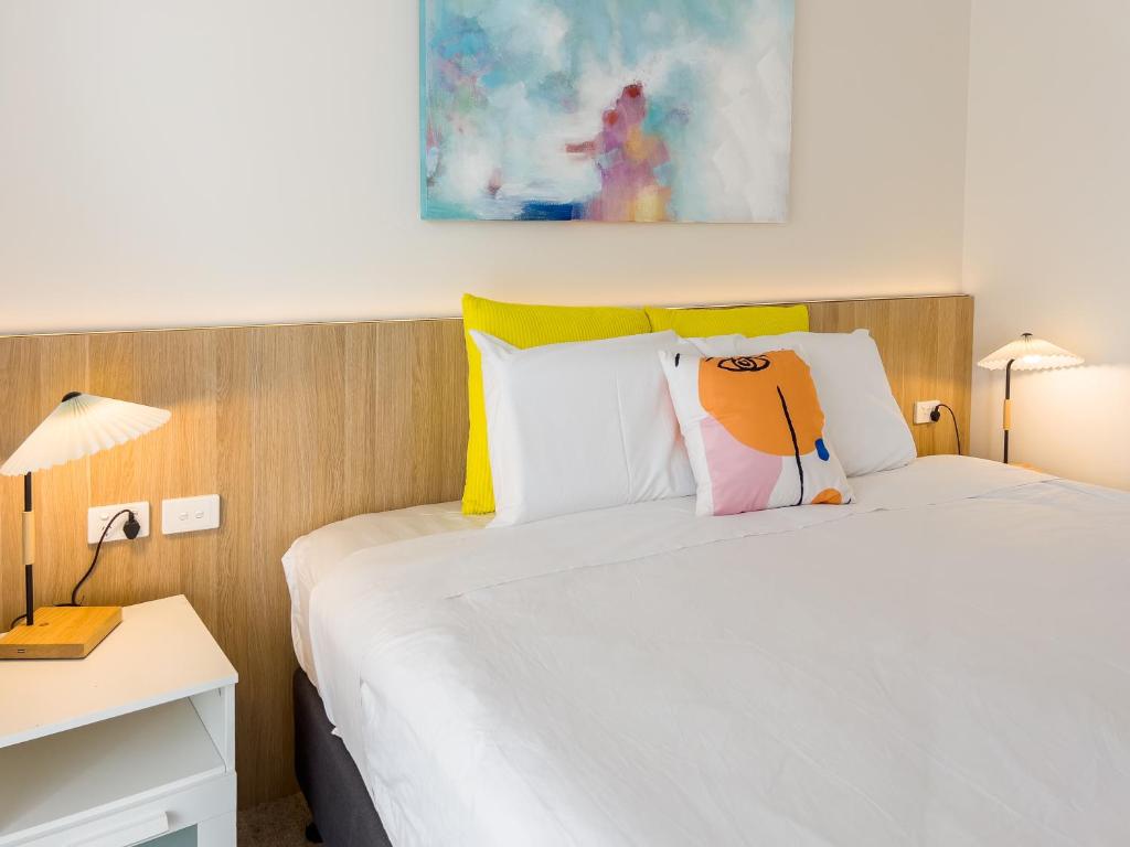 仙女港A1 Motels and Apartments Port Fairy的一间卧室配有一张床和一张带两盏灯的书桌。