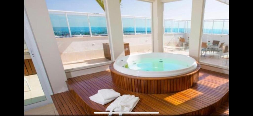 巴西利亚Flat hotel saint moritz的设有一个大浴缸的大窗户