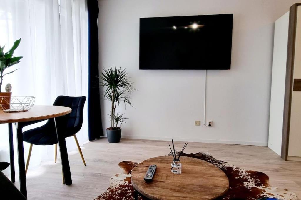 埃尔克拉特Schönes Apartment in Erkrath, Nähe Düsseldorf的客厅配有桌子和墙上的电视