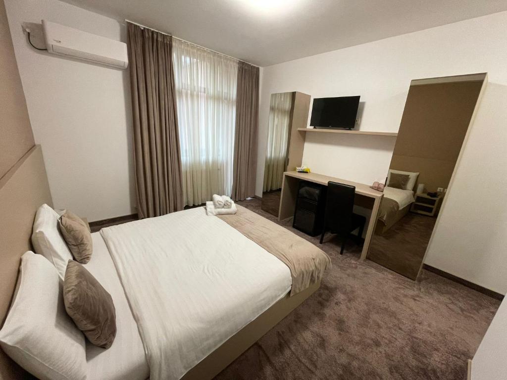 布加勒斯特Hotel Rivoli的配有一张床和一张书桌的酒店客房