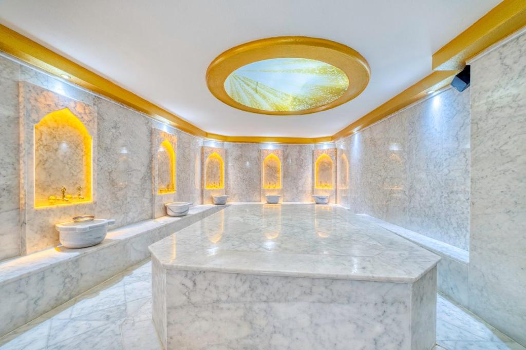 阿拉尼亚Aria Riva Apart Hotel的大型大理石浴室设有圆镜子天花板