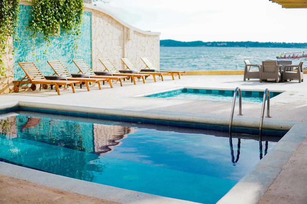 卡塔赫纳Hotel Caribbean Cartagena的水边带躺椅的游泳池