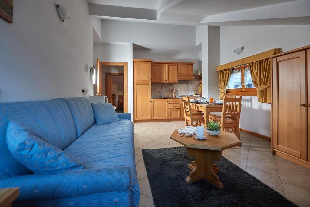 博尔米奥Sci运动公寓式酒店的客厅配有蓝色的沙发和桌子