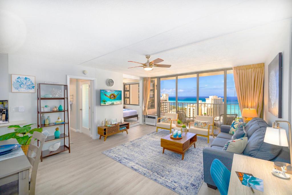 檀香山Waikiki Upscale 1 BR - Ocean Views - Parking的客厅设有蓝色的沙发和海洋