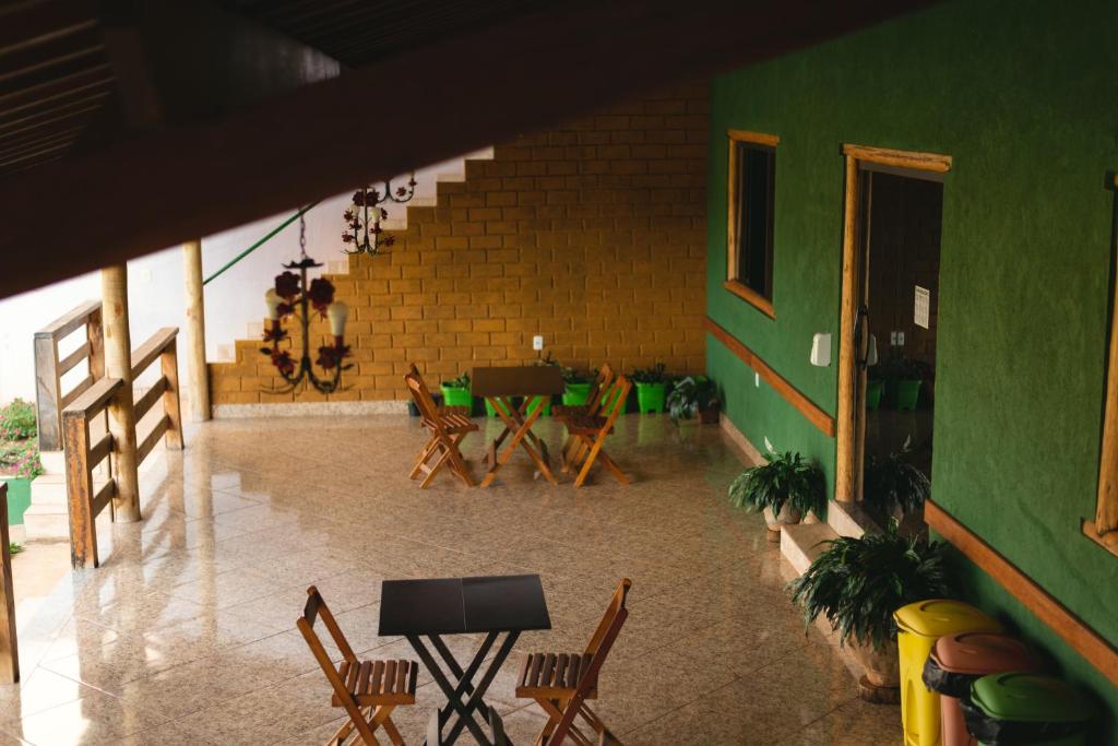 圣安娜杜里亚舒Pousada Bela Vista do Ismail - Lapinha da Serra的一间设有椅子和桌子的房间,以及绿色的墙壁